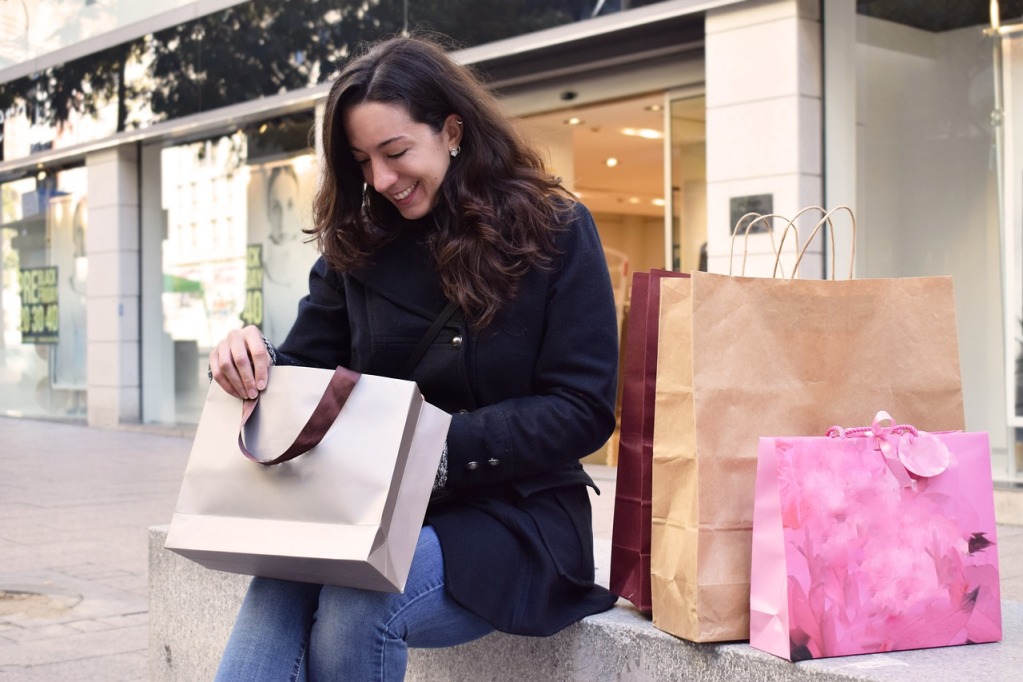 Eine Frau sieht lächelnd in eine Einkaufstasche
